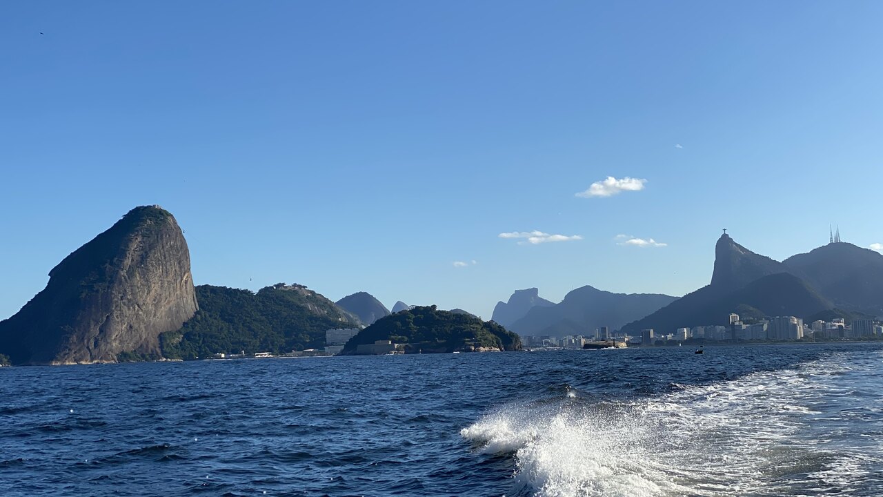Lancha ancorada em frente à Mureta da Urca com Pão de Açúcar ao fundo durante pôr do sol