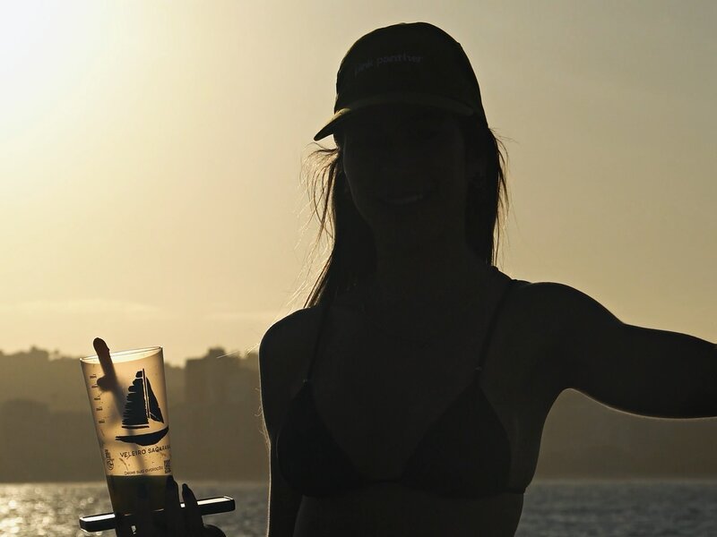 Silhueta com drink ao pôr do sol na lancha durante despedida de solteira