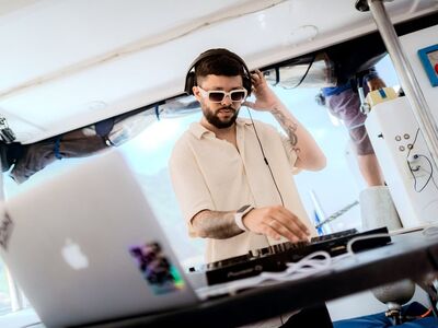 DJ profissional tocando na lancha com headphones e controladora